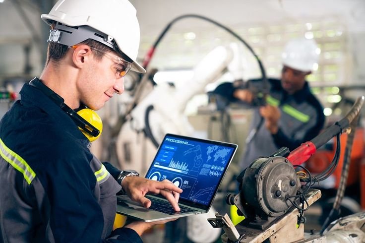 young factory worker working with adept robotic arm in a workshop industry robot programming software for automated manufacturing technology 